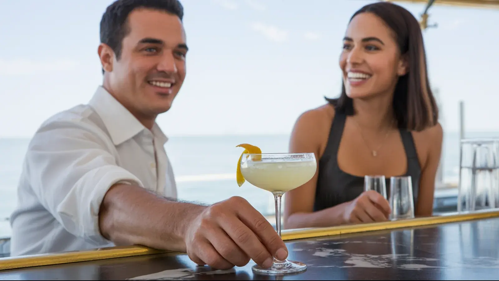 The owner of a cocktail bar at work with a customer, in a bright real moment