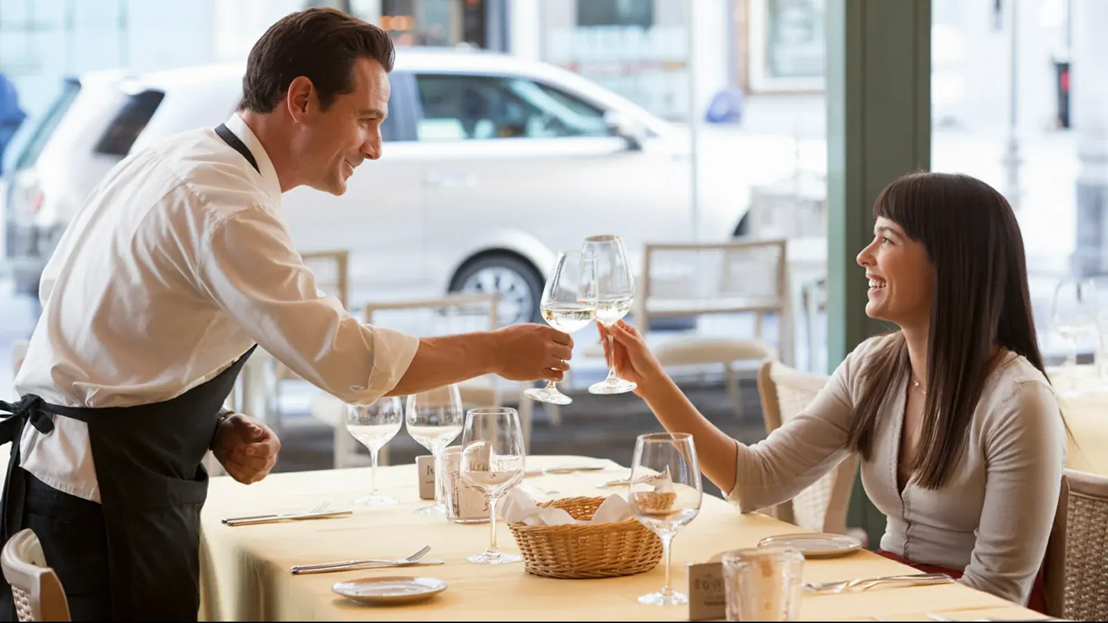 El dueño de un restaurante atendiendo a un cliente, en un momento real y luminoso